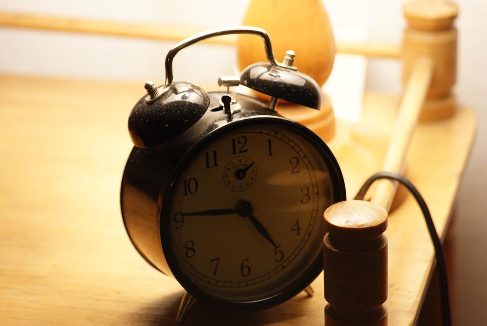 Jam weker di atas meja sebagai pengingat batas waktu